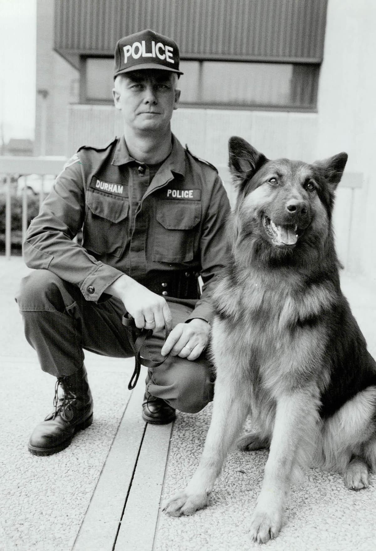 A police officer kneeling down next to a dog