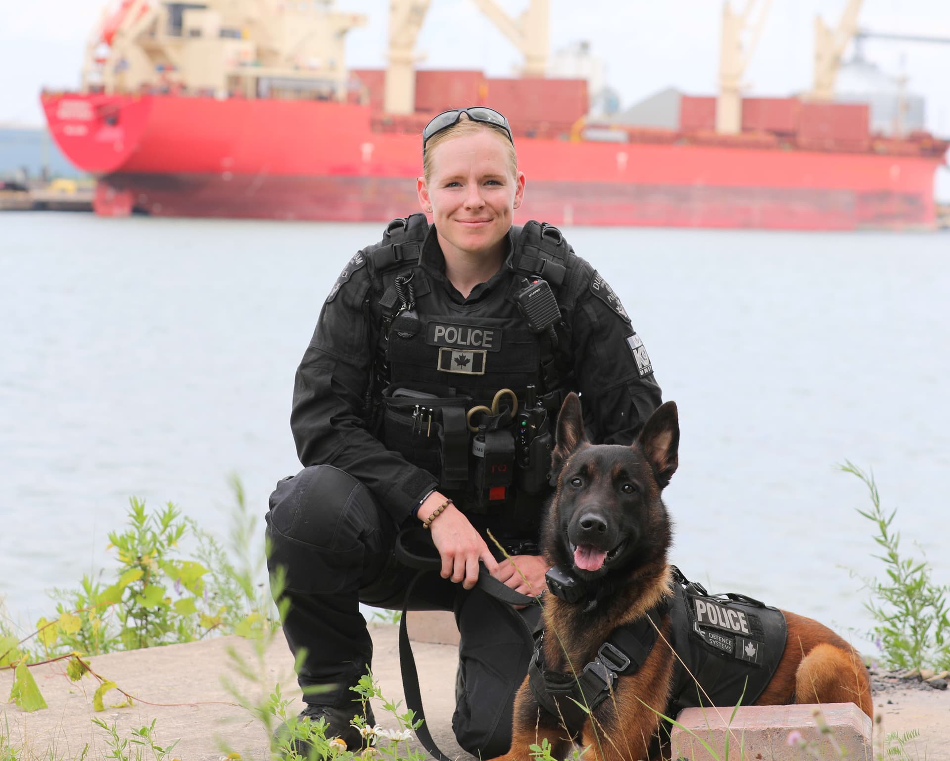 A police officer kneeling next to a dog