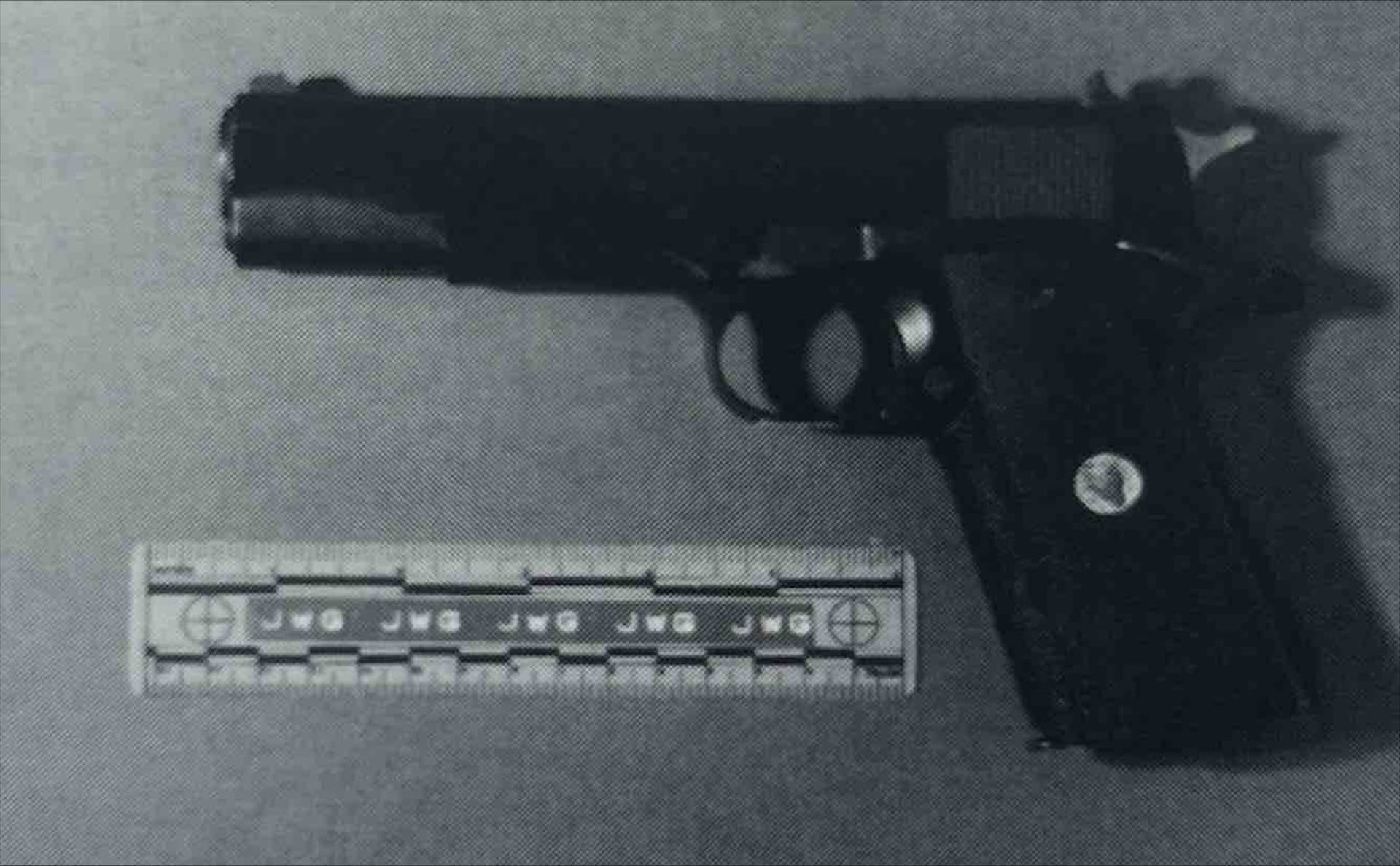 A black and white photo of a gun and a ruler